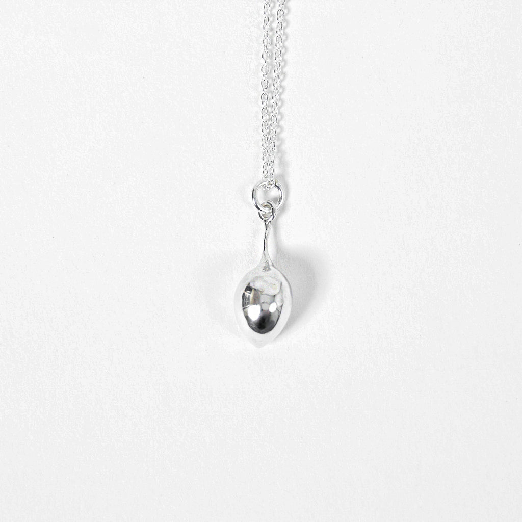 close up of sterling silver olive pendant on silver chain