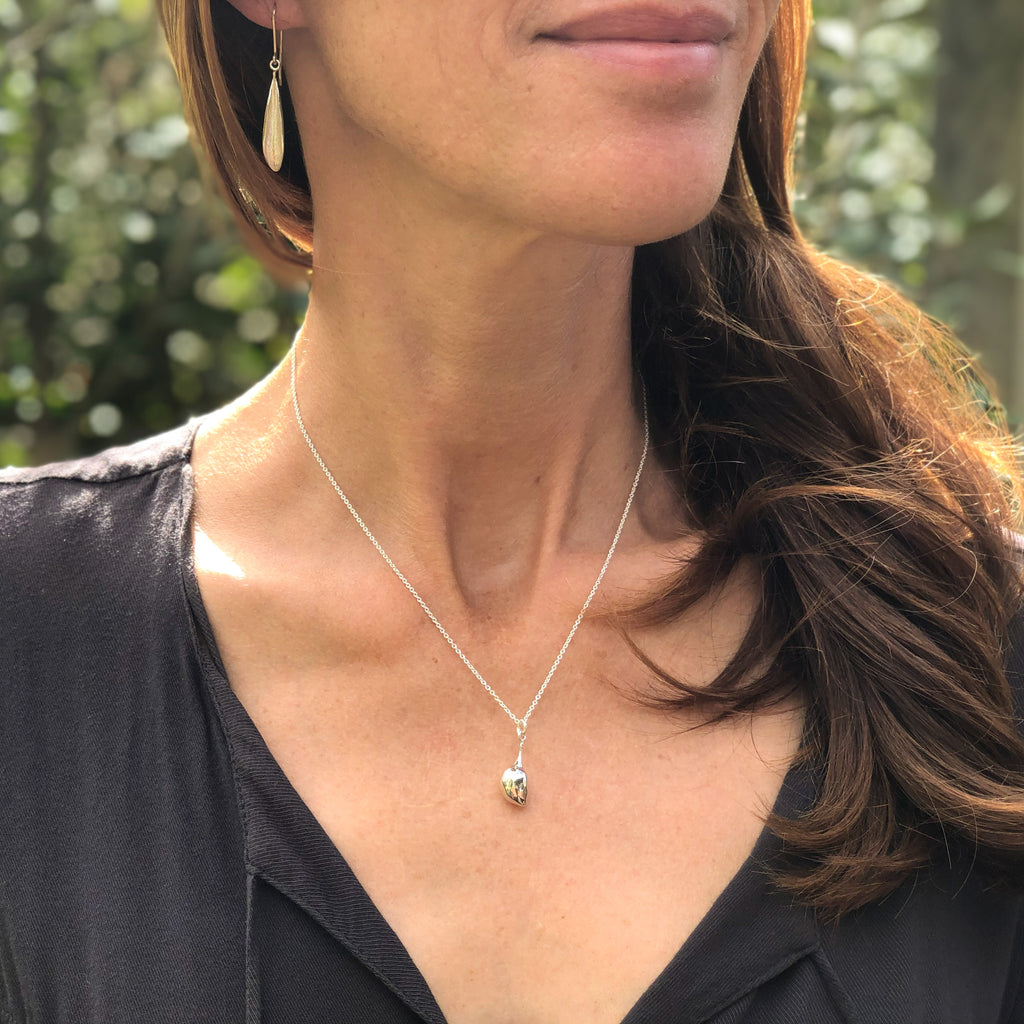 Model wearing sterling silver olive leaf earrings and a sterling silver olive pendant necklace.
