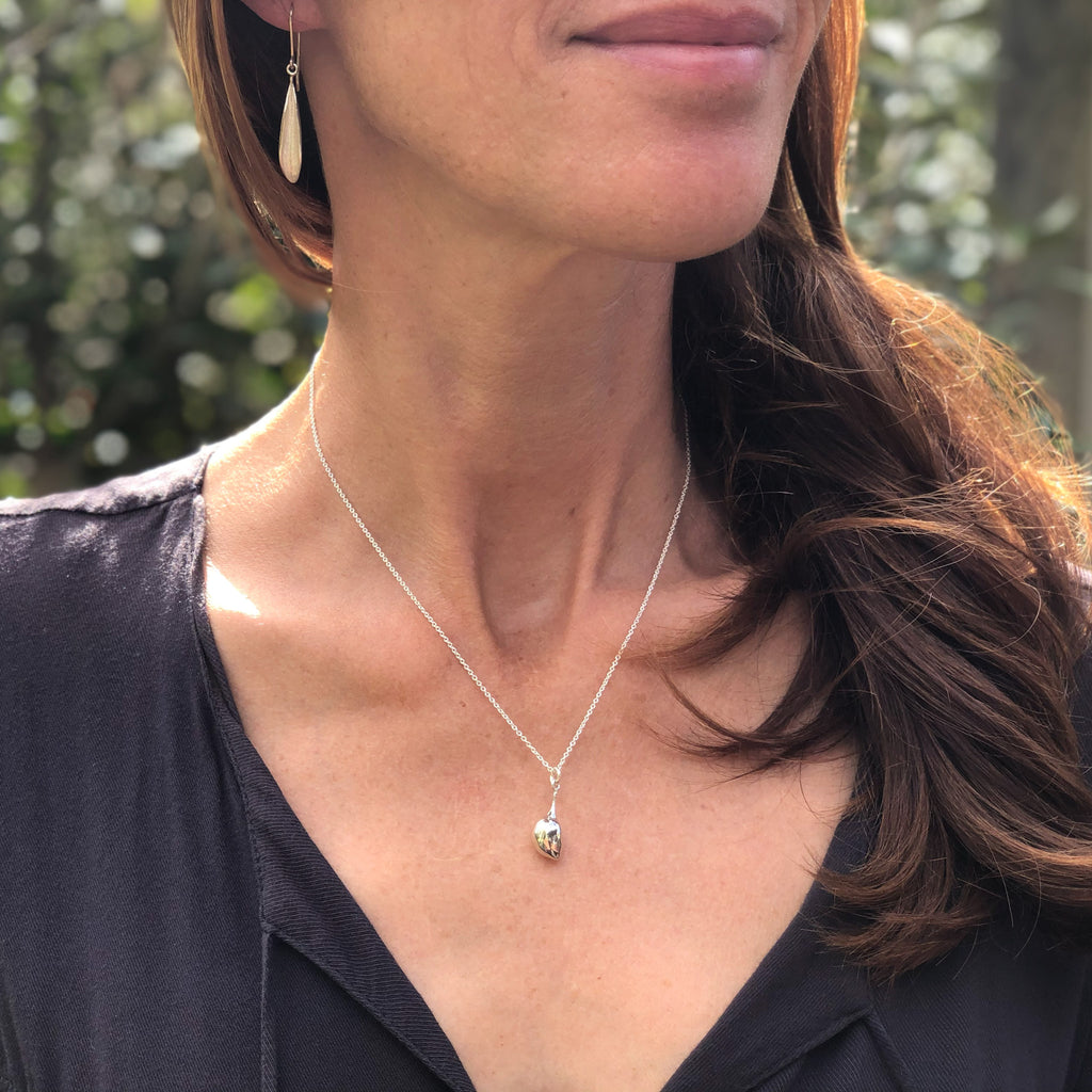 Photo of woman wearing sterling silver olive pendant on chain and dangly sterling silver olive leaf earrings