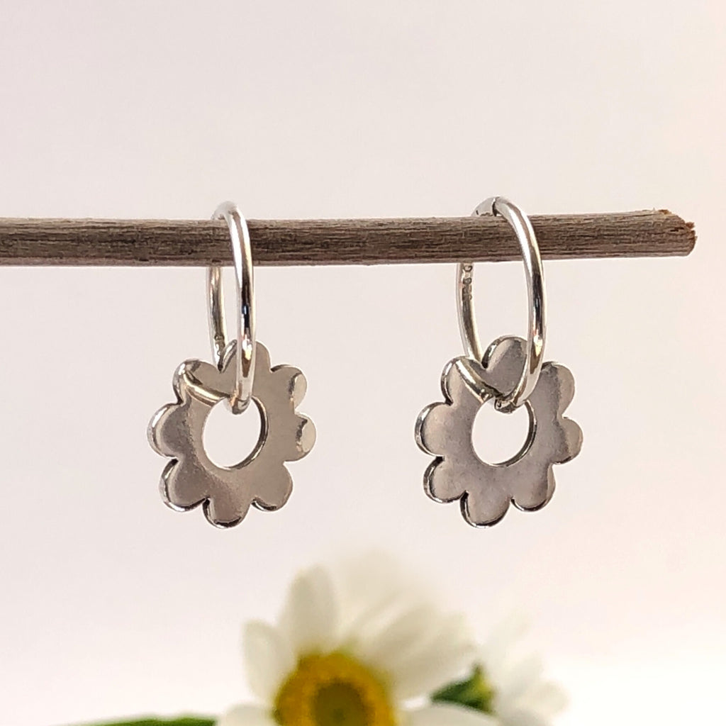 Sterling silver around earring withscalloped edges  swinging freely through the centre hole on a sterling silver sleeper.
