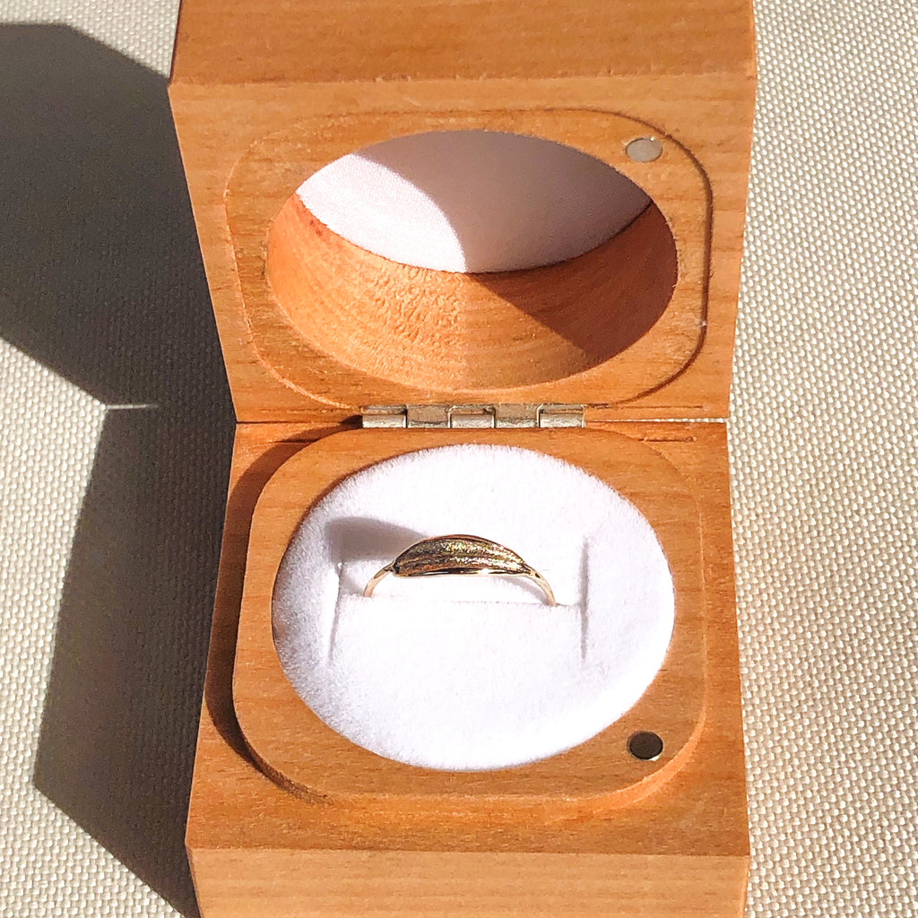 9k solid gold dainty olive leaf ring in wooden ring box.