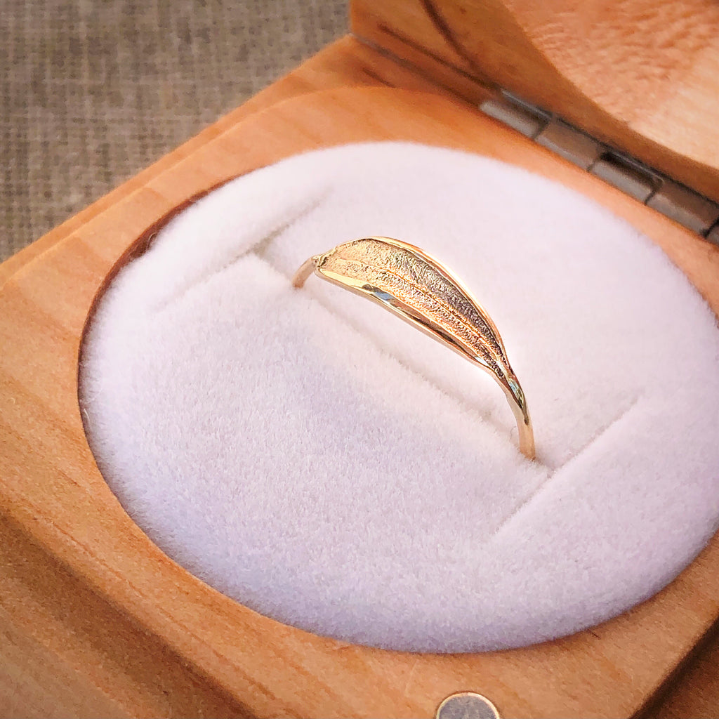 9k solid gold dainty olive leaf ring in wooden ring box.